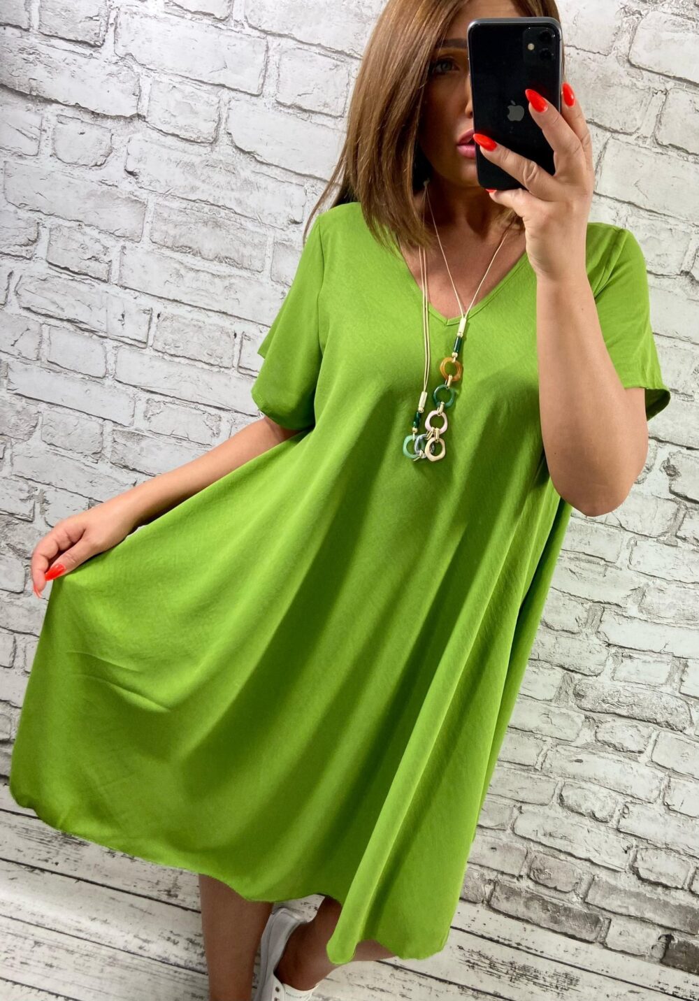 Limetkovozelené voľné šaty s výstrihom do V a krátkymi rukávmi, vhodné pre moletky, s výrazným náhrdelníkom
