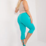 lus size žena v tyrkysových capri nohaviciach s vyšším pásom a vreckami na zips