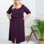 Plus size žena v elegantných fialových šatách s trojštvrťovými rukávmi a viazačkou vo výstrihu