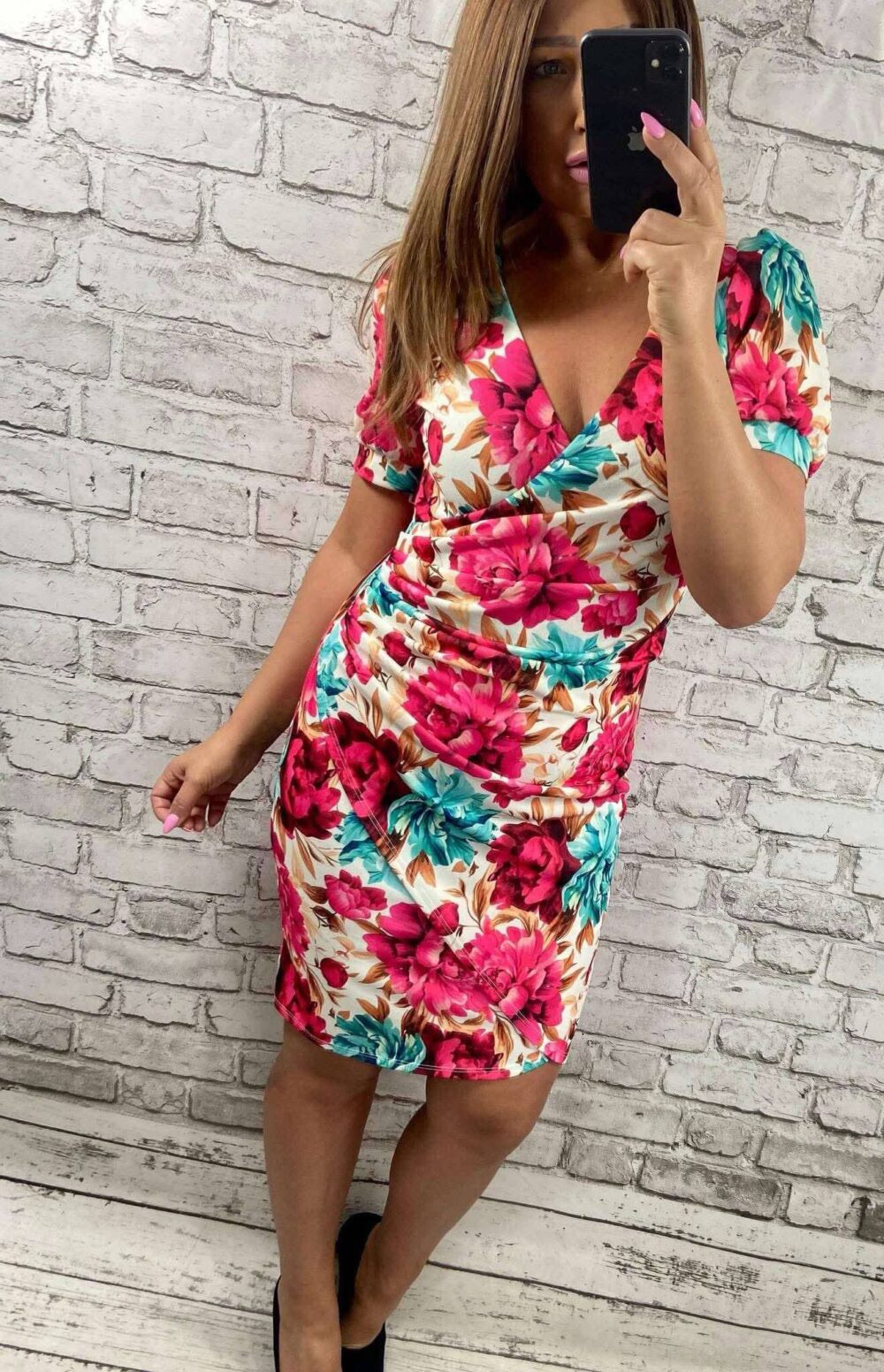 Plus size žena v elegantných šatách s pivonkovým a ibištekovým vzorom v ružovej a tyrkysovej farbe, s výstrihom do V a krátkymi rukávmi.