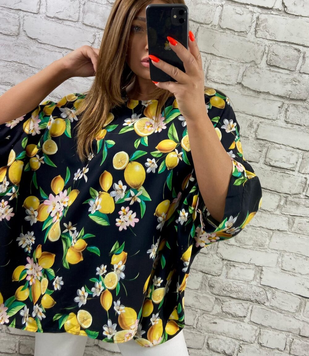 Voľná čierna tunika s citrónovým vzorom a netopierími rukávmi, vhodná až do veľkosti 62, v kombinácii s čiernymi nohavicami.