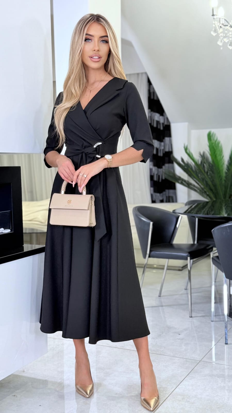 Elegantné čierne midi šaty so striebornou prackou a prekladaným výstrihom.