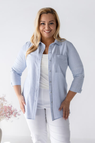 Dámska plus size bavlnená blúzka s jemnými modrými pásikmi, 3/4 rukávmi a voľnejším strihom, kombinovaná s bielymi nohavicami.