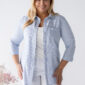 Dámska plus size bavlnená blúzka s jemnými modrými pásikmi, 3/4 rukávmi a voľnejším strihom, kombinovaná s bielymi nohavicami.