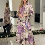 Dlhé elegantné kvetované šaty pre moletky so smotanovým podkladom, fialovým vzorom, košeľovým golierom, balónovými rukávmi a látkovým opaskom.