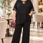 Čierny spoločenský nohavicový komplet pre plus size ženy so širokými nohavicami, voľným vrchným dielom a štrasovými kamienkami pri výstrihu a na rukávoch.
