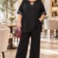 Čierny spoločenský nohavicový komplet pre plus size ženy so širokými nohavicami, voľným vrchným dielom a štrasovými kamienkami pri výstrihu a na rukávoch.