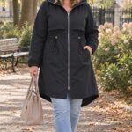 Čierna dámska plus size parka s kapucňou, sťahovaním v páse, zapínaním na zips a predĺženým zadným dielom.