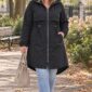 Čierna dámska plus size parka s kapucňou, sťahovaním v páse, zapínaním na zips a predĺženým zadným dielom.