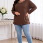 Plus size modelka v hnedej tunike s perlovým zdobením okolo výstrihu, spadnutými ramenami a dlhými rukávmi. Voľný, predĺžený strih dopĺňajú svetlomodré úzke rifle a béžové sandále na podpätku.