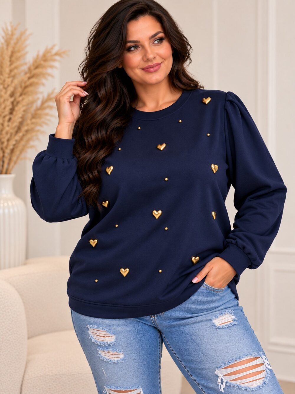 mikina-modra-srdiecka2 Tmavomodrá dámska plus size mikina so zlatými vystúpenými srdiečkami a drobnými zlatými ozdobami na prednej strane. Má okrúhly výstrih, jemne nariasené ramená a dlhé rukávy s manžetami. Modelka ju nosí so svetlomodrými rifľami.