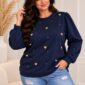Tmavomodrá dámska plus size mikina so zlatými vystúpenými srdiečkami a drobnými zlatými ozdobami na prednej strane. Má okrúhly výstrih, jemne nariasené ramená a dlhé rukávy s manžetami. Modelka ju nosí so svetlomodrými rifľami.